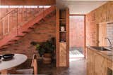 Kitchen, Ceramic Tile Backsplashe, Wood Cabinet, Concrete Floor, Wood Counter, and Drop In Sink Light enters the kitchen from the courtyard through one of the glass doors.  Photos from Before & After: A Cramped Home in Mexico Gets a Drastic Makeover on a Tight Budget