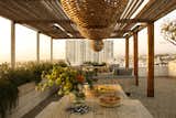 The terrace area features a reed and metal pergola structure designed by PSS Design Cult.