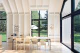 Dining Room, Chair, Light Hardwood Floor, Pendant Lighting, and Table Along both lengths of the house are three tall glass panels that frame views of the tranquil nature outdoors.  Photo 20 of 163 in Products by Joe March from A Dreamy Lakeside Cottage Embodies the Spirit of Simple Living