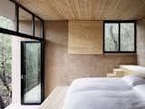 Rammed earth, brick, and wood give the bedroom a rustic, minimalist look.