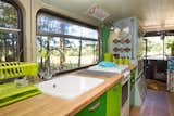 Kitchen, Medium Hardwood Floor, Wood Counter, Wall Oven, and Drop In Sink A fully-equipped kitchen with a sink, oven and cooktop.  Photo 6 of 13 in This Double-Decker Bus Offers an Eclectic Glamping Experience
