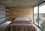 Bedroom, Bed, Shelves, Concrete, Table, Lamps, and Night Stands Built-in concrete shelves in one of the guest bedrooms.  Bedroom Concrete Shelves Night Stands Photos from This Stacked Concrete Home Is Not Your Typical Golf Course Dwelling