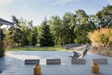 Outdoor, Woodland, Large Patio, Porch, Deck, Wood Patio, Porch, Deck, Decking Patio, Porch, Deck, Trees, Grass, and Back Yard The large outdoor terrace surrounded by trees.  Photo 10 of 13 in Hellum House by Dwell from Relax and Recharge at This Charming Norwegian "Hytte" Rental