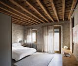 Bedroom, Table Lighting, Night Stands, Concrete Floor, Lamps, Bed, Rug Floor, and Wall Lighting A dialogue between ancient and contemporary can be seen in the bedroom.  Photo 10 of 15 in A Spanish Architect Transforms a Medieval Townhouse Into a Stunning Rental