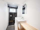 The bathroom has an elevated shower area with frosted glass windows that look out to a quiet alley.
