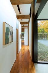 Hallway and Medium Hardwood Floor Art work along the walls of the hallway that connect the wings.  Photo 5 of 16 in This Glass House and "Shiny Shed" Merge With Nature in Minnesota