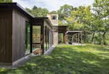 Outdoor, Back Yard, Trees, and Small Patio, Porch, Deck A patio that is accessible via the living room.  Photo 7 of 16 in This Glass House and "Shiny Shed" Merge With Nature in Minnesota