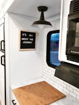 Kitchen, Marble Counter, Subway Tile Backsplashe, and Ceiling Lighting The kitchen workstation faces a window.  Photo 16 of 16 in Hit the Road With This Chic Camper on Sale For $28K