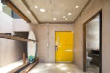 The bright yellow door adds a playful touch to a concrete abode. There is ample storage for surf gear throughout the dwelling, creating a connection between inside and out.