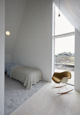 Bedroom, Chair, Pendant, Bed, Light Hardwood, and Rug A full-height window frames views of the dunes.  Bedroom Light Hardwood Pendant Chair Rug Photos from Rent This Danish A-Frame For Your Next Nordic Escape