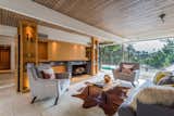 Living Room, Sofa, Shelves, Recessed Lighting, Coffee Tables, Chair, Track Lighting, Standard Layout Fireplace, Rug Floor, and Ceiling Lighting  Photos from Composer Paul Buckmaster's Midcentury Gem Asks $1.39M