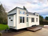 Resting upon a 28’ x 8.5’Iron Eagle Tiny House Trailer with (3) 7K axles, trailer brakes, and road lighting, Coastal Craftsman has board and batten siding with Pacific Cedar accents,  a
standing seam metal roof, and 9-lite glass exterior door with handle set.
