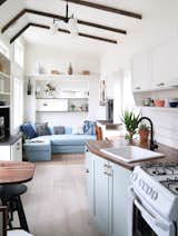 Kitchen, Wall Oven, Drop In, Light Hardwood, Wood, Pendant, Ceramic Tile, Range, Colorful, and White Indoor plants add a sense of dynamism to the interiors.  Kitchen Wall Oven Range White Drop In Pendant Photos from This Tiny Trailer Home Boasts Soothing Beach Vibes
