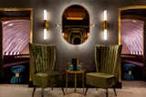 Dining Room, Table, Wall Lighting, and Chair The intimate, den-like space has vaulted ceilings, wood-paneled walls, and chairs and stools upholstered in olive, coral pink, and turquoise velour.  Photo 9 of 11 in 10 London Bars Every Design Lover Should Visit