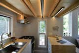 The galley-style kitchen—located below the sleeping loft— has identical operable windows on each side to bring in an abundance of light and cross breezes.&nbsp;