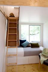 Staircase and Wood Tread A retractable ladder, and no built-in furniture or cabinetry in the main living area makes a range of layouts and arrangements possible.  Photo 8 of 10 in This Midcentury-Inspired Tiny House Radiates Clever Design