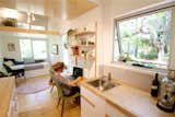 Office, Desk, Chair, Shelves, Light Hardwood Floor, and Bookcase The front door leads into a tall space where the ceiling rakes upwards toward a generous feature window.  Photo 7 of 10 in This Midcentury-Inspired Tiny House Radiates Clever Design