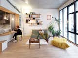 Living, Sofa, Lamps, Desk, Shelves, Light Hardwood, Chair, Coffee Tables, Rug, Pendant, and Wall  Living Desk Sofa Rug Photos from This Compact Home in Paris Has Nearly 70 Concealed Closets