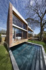 Outdoor, Small, Back Yard, Trees, Grass, Wood, and Large Insulated glass was used for the floor to ceiling windows.  Outdoor Small Wood Grass Photos from An Airy New Pavilion Lets One Family Practically Live in a Park