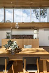 Dining Room, Medium Hardwood Floor, Pendant Lighting, Table, and Chair Venetian blinds were installed on the exterior of the windows to mitigate heat.  Search “venetian vicissitude” from An Airy New Pavilion Lets One Family Practically Live in a Park