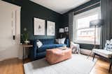 She painted the walls a deep green—Salamander by Benjamin Moore—added a blue velvet pull-out couch, new artwork, new furniture, and picture rail molding.
