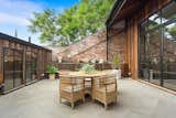Outdoor, Large Patio, Porch, Deck, Rooftop, and Wood Fences, Wall Polished concrete and exposed bricks give the home an industrial look.  Photos from The Glowing Converted Warehouse of Painter Fred Cress Is Open For Bids