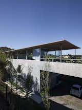 Garage and Den Room Type Through a winding gravel path cutting through the native vegetation, one arrives at a parking garage, which is located the below the roof’s large, overhanging eaves.  Photo 9 of 12 in A Concrete Abode in Uruguay Embraces its Beachfront Setting