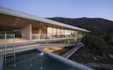 Outdoor, Small Pools, Tubs, Shower, Side Yard, Large Patio, Porch, Deck, and Concrete Patio, Porch, Deck The staircase and ramp serve as vertical circulation, connecting the base and access levels. 

  Photos from This Chilean Concrete Home Levitates Off a Coastal Slope