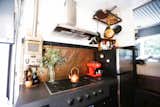 Kitchen, Metal Backsplashe, Cooktops, Refrigerator, and Range Hood “Living in a tiny home also naturally directs you towards purposeful activities,” says Fishbeyn.  Photo 9 of 13 in A California Couple Customize Their Tiny Home With Multi-Layered Interiors