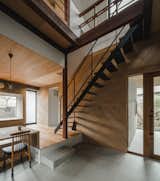 The architects installed modern, floating stairs with a wooden tread and steel railings.
