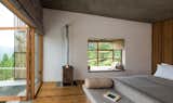 Bedroom, Bed, Medium Hardwood Floor, and Bunks In the chalet room, the bed, table, and seating were designed as a island unit finished in smooth cement render.  Photo 8 of 15 in The Kumaon by Dwell from A New Retreat in the Indian Himalayas Captures Epic Views