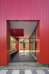 Hallway and Dark Hardwood Floor Though this particular house was built on-site, Assadi designed the components to mimic prefabrication.   Photos from This Modular Home in Chile Has Us Seeing Red—in a Good Way