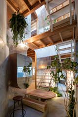 Living, Bench, Table, Concrete, Stools, Wall, and Floor This “alley” veers then off at a right angle to become an indoor “courtyard” lined with green plants near the back section of the house.  Living Floor Stools Wall Photos from This Whimsical Home in Japan Encourages Play and Exploration