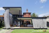 Outdoor, Back Yard, Large Patio, Porch, Deck, Grass, and Metal Fences, Wall They wanted their new home to better connect with the surrounding garden site, and include a sheltered outdoor space that would allow them to dine comfortably outdoors even in the hot summer months.  Photos from A Steel Mesh Curtain Wraps Around This Renovated Australian Home