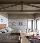 Bedroom, Rug Floor, Bed, Chair, Light Hardwood Floor, and Wall Lighting On the opposite end of the pool is an ensuite bedroom that is connected to a smaller, corner terrace.

  Photo 8 of 14 in Two Eclectic Volumes Unite This  Contemporary Chilean Home