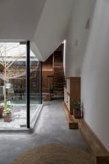 Hallway and Concrete Floor From the living area, floating stairs lead up to the second and third floor, which were designed as two compact levels stacked above the "wooden house" volume on the ground floor.    Photo 9 of 13 in A Vietnamese Abode Draws In Light With a Glass Atrium