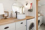 Laundry Room, Side-by-Side, White Cabinet, and Wood Counter A large oval mirror makes the bathroom look and feel larger.

  Photo 16 of 17 in A Family Customizes an Off-Grid Tiny Home With Online Design Tools