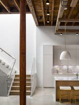 Kitchen, Marble, Concrete, Track, Pendant, Marble, White, and Undermount A white metal staircase leads up to the master bedroom.  Kitchen Track Concrete Undermount Photos from A Historic Propeller Factory Is Converted Into a Gorgeous Home