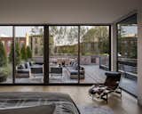Bedroom, Bed, Light Hardwood Floor, Chair, and Rug Floor The fully glazed master bedroom opens onto a large rooftop terrace that overlooks Jersey City's Paulus Hook neighborhood.

  Photo 7 of 14 in A Historic Propeller Factory Is Converted Into a Gorgeous Home