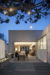 Outdoor, Wood Patio, Porch, Deck, Back Yard, Trees, Large Patio, Porch, Deck, Concrete Fences, Wall, and Hanging Lighting A new walkway and outdoor terraces are part of the addition.

  Photos from A Cramped Midcentury Bungalow Gets a Luminous New Addition