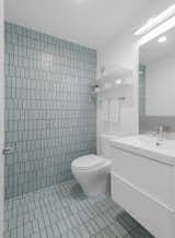Bath Room, Two Piece Toilet, Ceramic Tile Floor, Wall Lighting, and Drop In Sink The aqua field tiles in the powder room echo the colors of the Pacific Ocean nearby.

  Photos from A Cramped Midcentury Bungalow Gets a Luminous New Addition