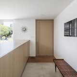 Doors, Wood, Swing Door Type, and Exterior A wood pivot door with a recessed, custom-cut coir doormat.

  Photo 5 of 15 in A Cramped Midcentury Bungalow Gets a Luminous New Addition