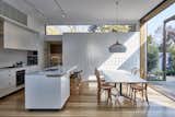 Dining, Track, Pendant, Chair, Table, Light Hardwood, and Stools Plenty of white finishes give the interiors a clean, bright look.  Dining Pendant Light Hardwood Track Stools Photos from Wooden Screens Shade This Sustainable Melbourne Residence