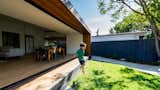 The original extension blocked airflow and sunlight into the house, which resulted in dark, cramped living spaces. By adding three massive sliding doors to open up the garden-facing wall of the house, Ong has made the interiors look and feel brighter and more spacious. 

  Photo 6 of 9 in A Melbourne Home Decreases in Size to Amp Up Its Outdoor Connection