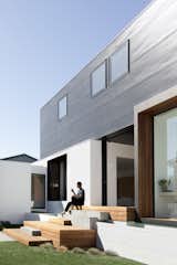 Outdoor, Grass, Side Yard, Small Patio, Porch, Deck, and Wood Patio, Porch, Deck By reducing the facade, which faces the strong western sun, the architects could minimize the amount of sunlight entering the building.  Photos from A Sleek Australian Dwelling Keeps its Cool With Passive Design