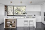Kitchen, Marble, White, Stone Tile, Wall Oven, Concrete, Cooktops, Ceiling, and Undermount The kitchen features a lovely CDK stone backsplash.

  Kitchen Stone Tile White Marble Undermount Photos from Two Timber-Clad Pavilions Make Up This Australian Family Retreat