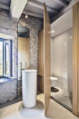While using the washbasin, the owner can enjoy outdoor views.  "The 'rarefacted' wooden wall generates a light visual relationship between bedroom and bathroom spaces," says Cisi.