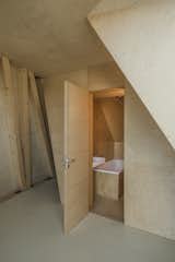 A bathroom is concealed discreetly behind the plywood walls.