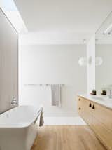 Wood flooring and cabinetry give the bathroom a warm, Zen-like feel.