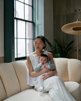 Zoe Chan Eayrs and her daughter Max relax on a Danish banana sofa that Chan + Eayrs reupholstered in Cream Pierre Frey velvet.